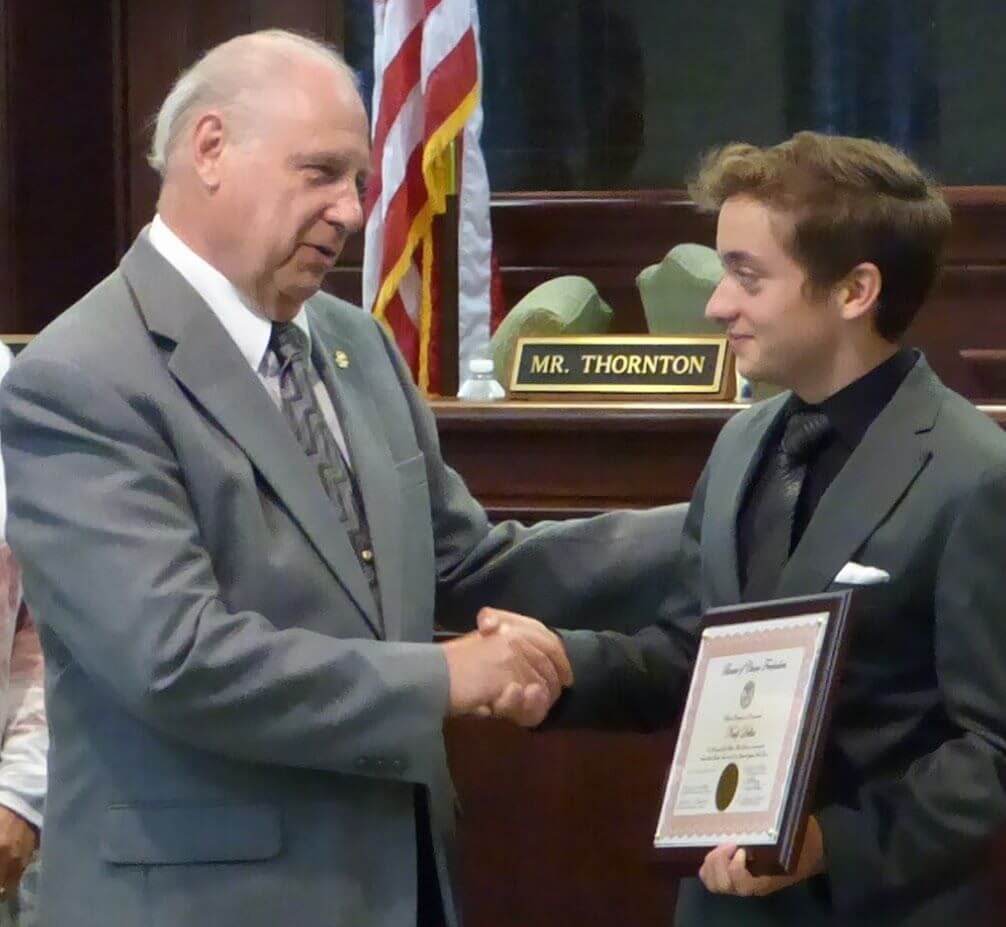 Freeholder Director Gerald Thornton congratulates Noah Dellas of Court House Sept. 8 on winning a gold medal in the first triathlon in the Special Olympics World Games in Los Angeles