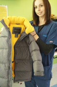 CompleteCare Health Network clinical assistant Megan Carbonneau shows off one of the coats that was received for donation at last year’s coat drive.