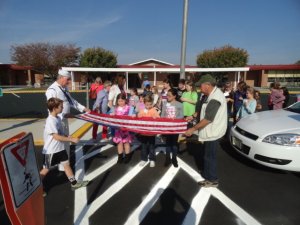 Vietnam War Veterans demonstrate how to fold an American flag for Maud Abrams students.