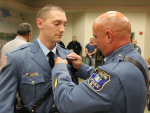 Matthew Ardelean receives his badge from Chief William McCormick.