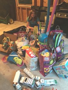 Hailey Rosenberger displays many of the summertime items she and her sister collected throughout the community. Among the items collected was a set of Hess trucks