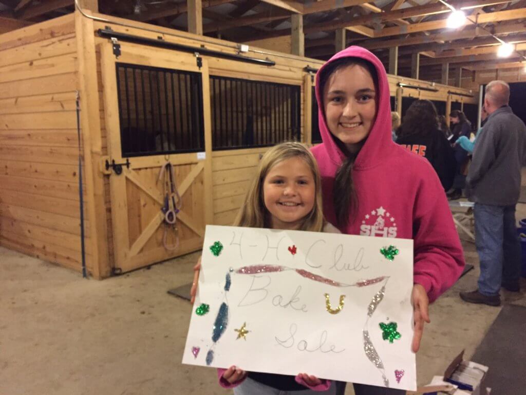 Devin Mathis and Coryn Dykhouse making a sign for the Star Hollow Riders bake sale.