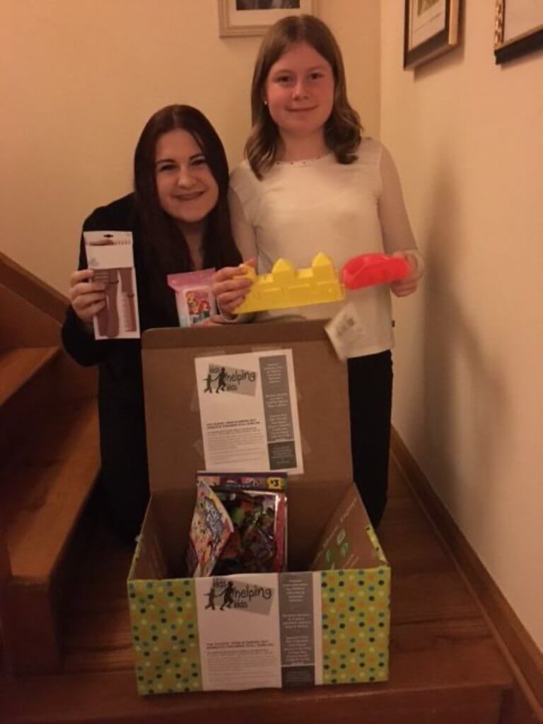 Alyssa and Hailey Rosenberger hold some donated items for CARA