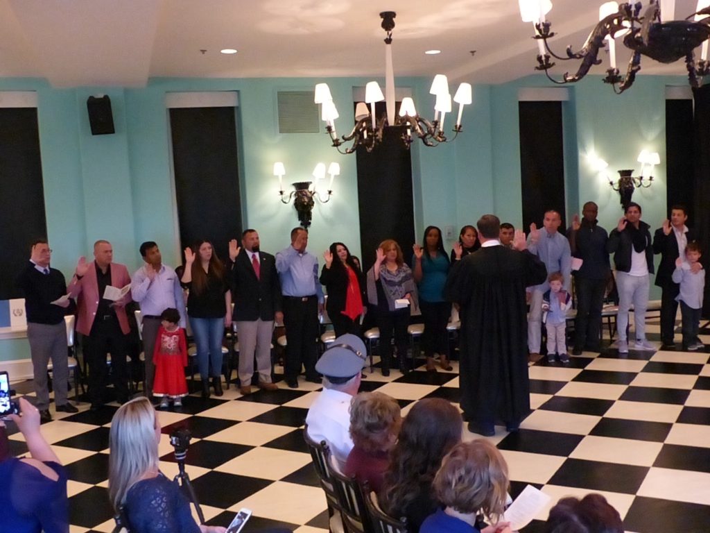 Superior Court Judge Michael R. Donohue administers the oath to the front row.