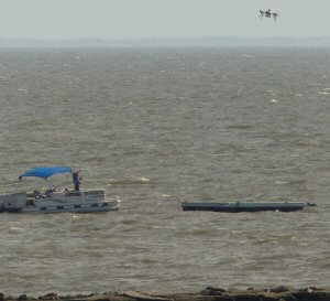 Drone hovers over barge.