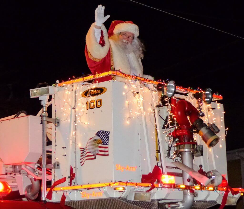 Santa greets boys and girls from the Court House Fire Department's aerial truck along North Main Street