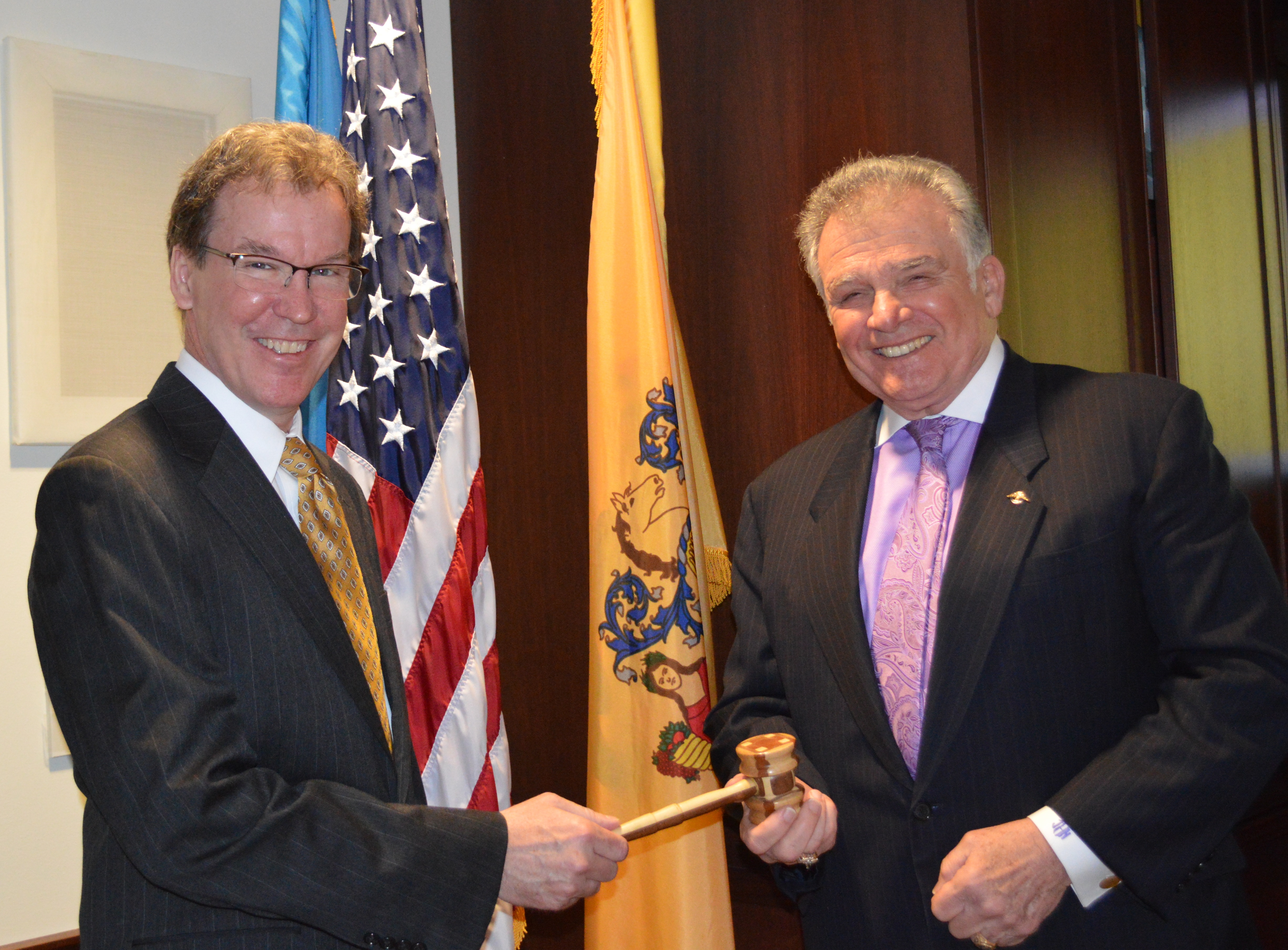 Bill Lowe (pictured left) congratulates Jim Hogan on his election as Commission Chairman and presents him with the meeting gavel. 