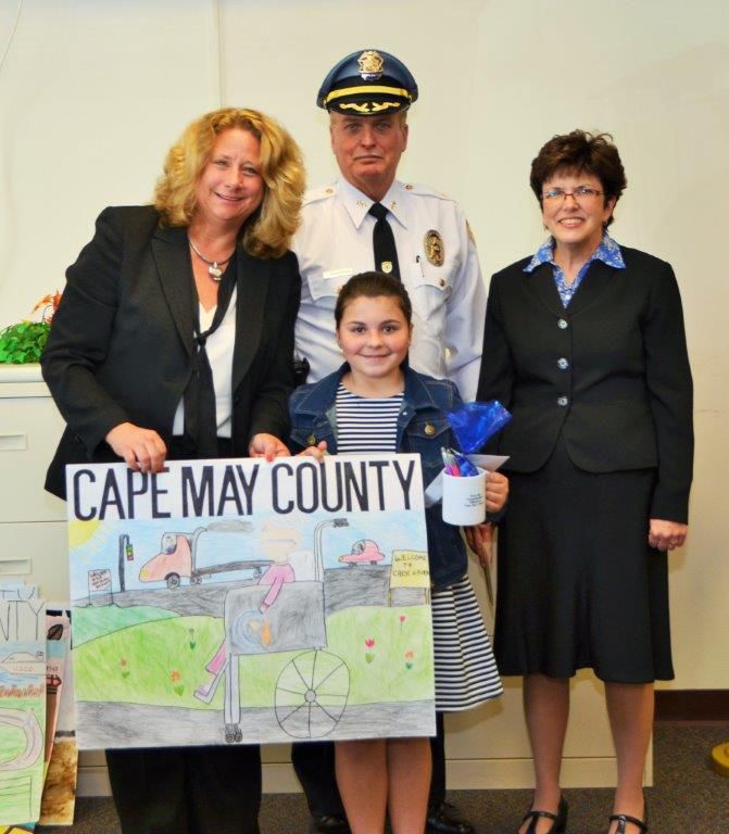 1st Place Winning Poster from 2016 by Paige Hearon (center) of Dennis Township Elementary with Surrogate Susan Sheppard (standing left)