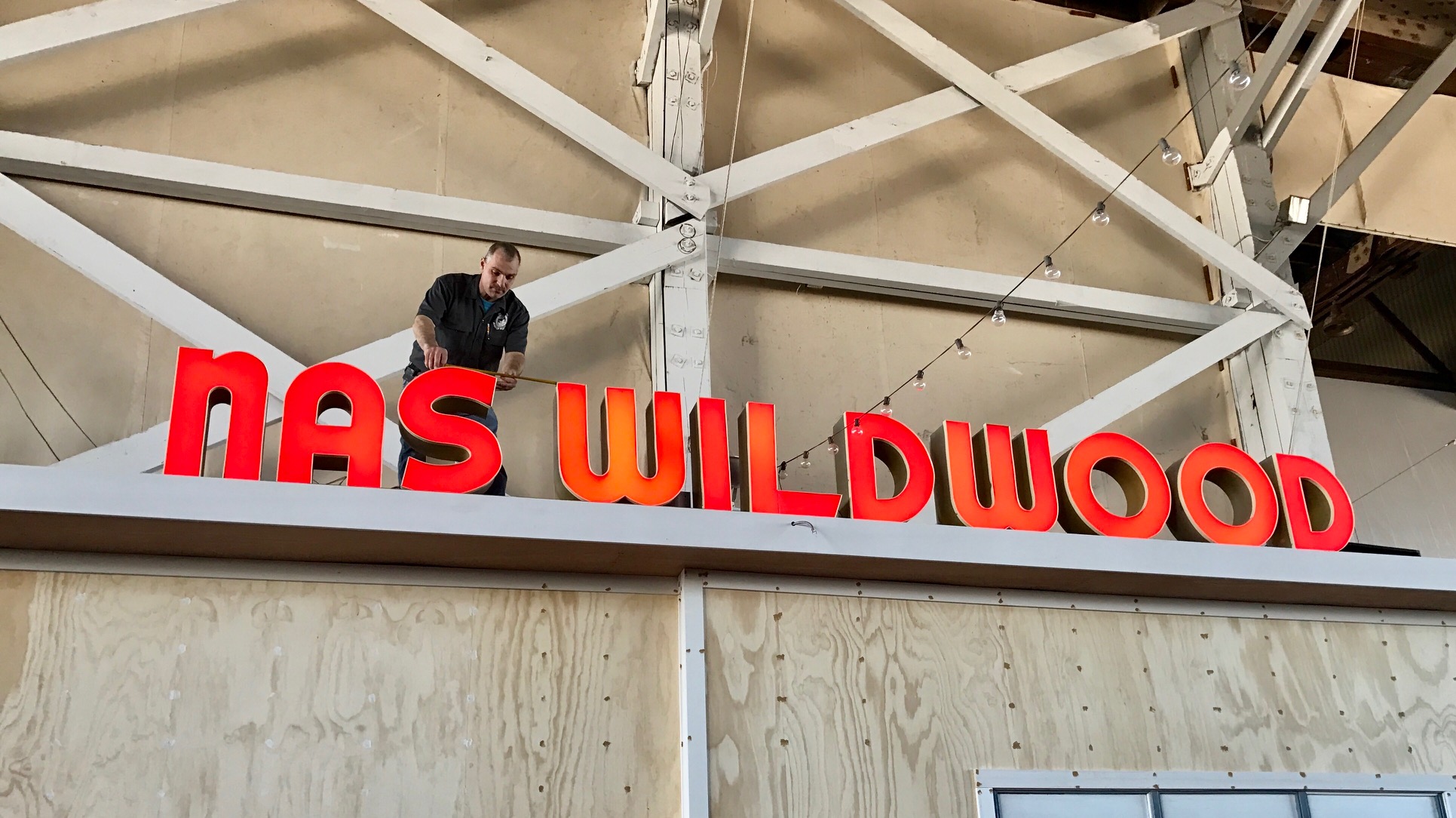 Maintenance Director Bob Moser places the newly lit letters in the heart of the museum above the “Radio Room.”