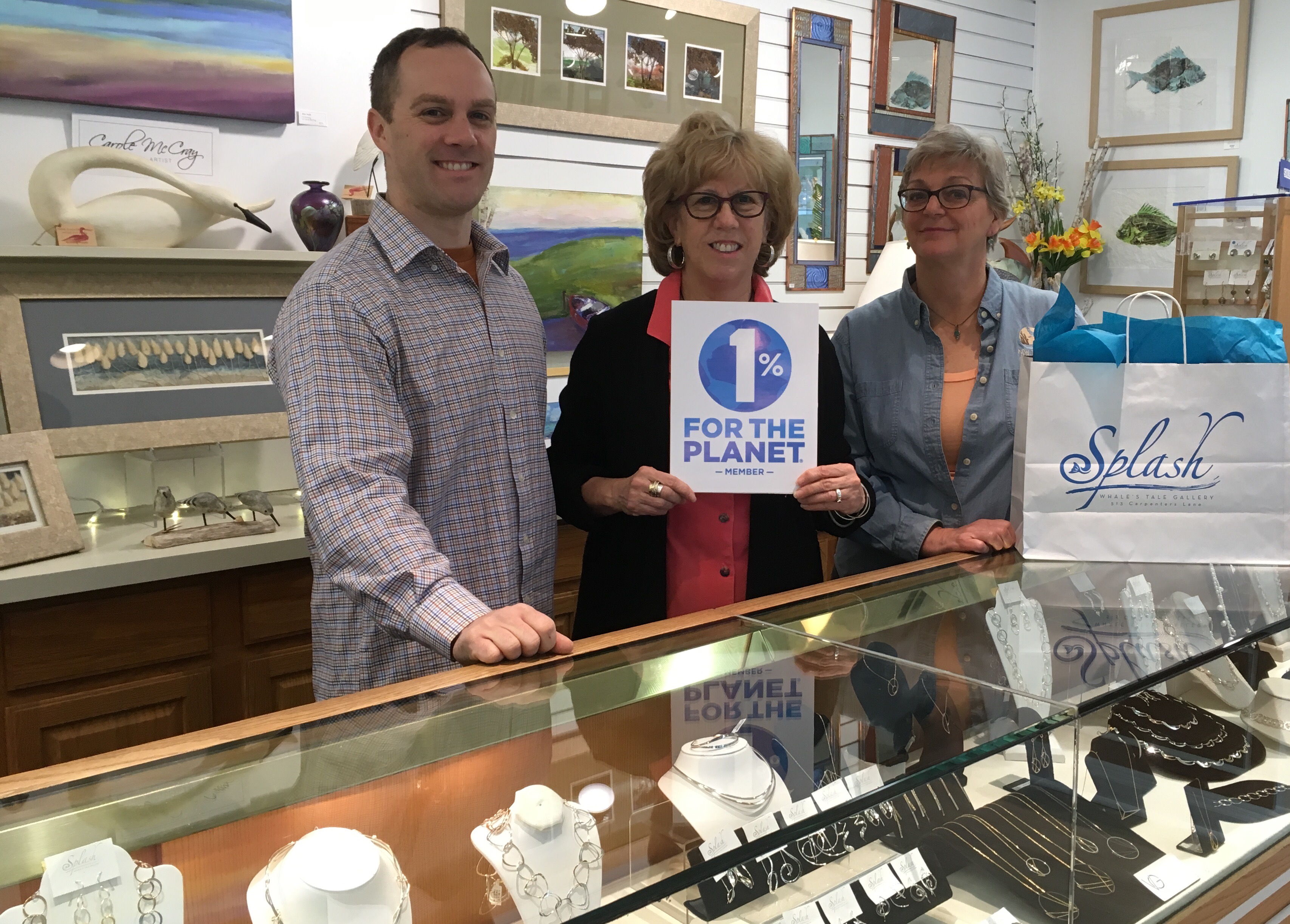 Travis and Hilary Pritchard proudly display the 1% for the Planet sign at Splash with Gretchen Whitman