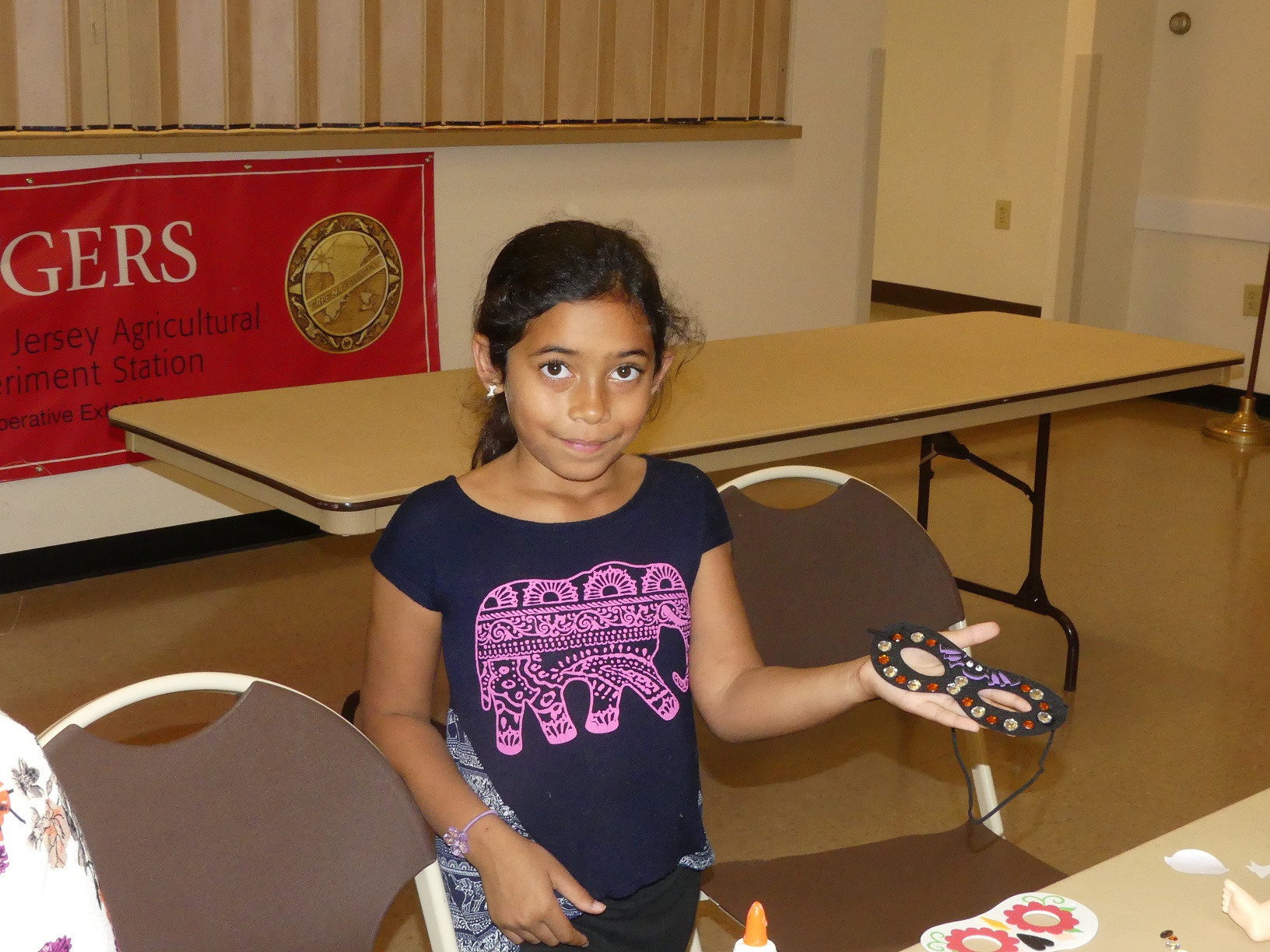 Amaya Ferrell (9) shows off the festive mask she made during the October meeting of the Grandparents Raising Grandchildren program at Rutgers Cooperative Extension of Cape May County.