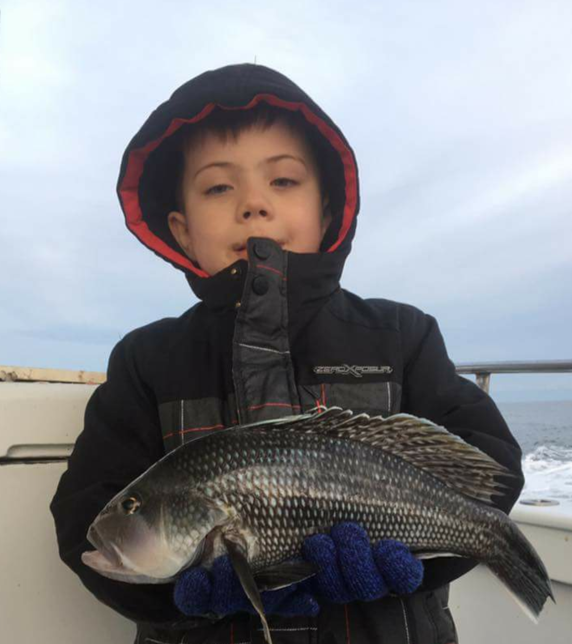 A young angler and his sea bass. 