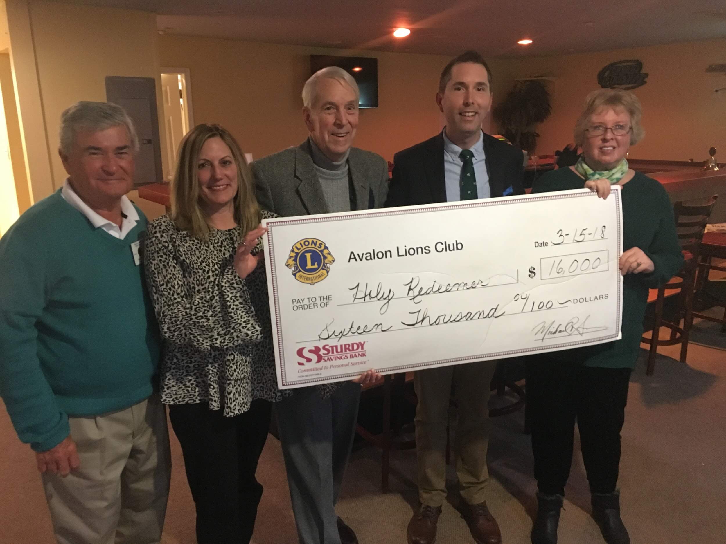 Avalon Lions Club members present a donation to Holy Redeemer during their March meeting.