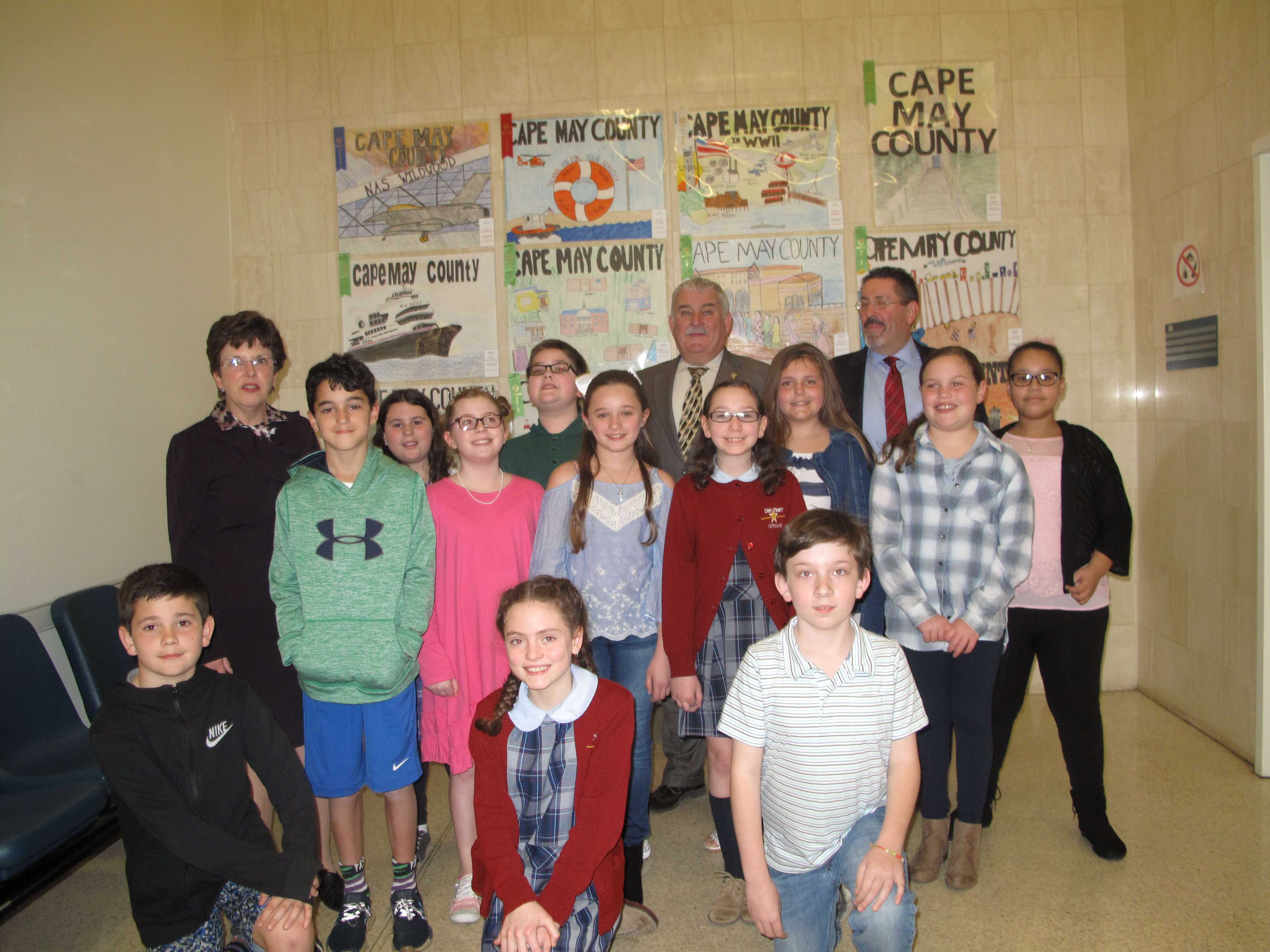 My County Poster Contest winners in front of their winning posters in the lobby of the courthouse during April. Kneeling in front are Clay Compton