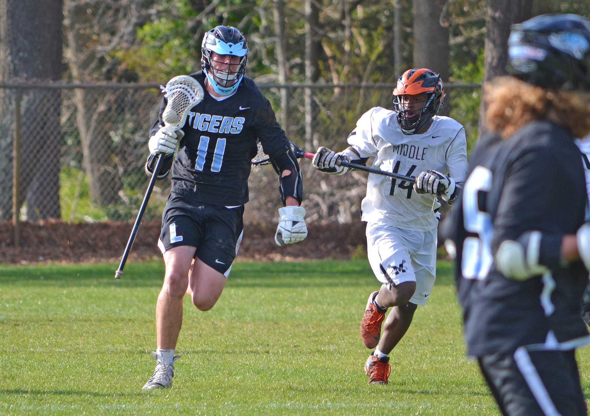 Lower Cape May’s Chase Mendyk (11) moves past Middle Township’s Tom Stahler in April 27’s boys lacrosse rivalry match-up in Court House. Mendyk had three goals in the Caper Tigers road win.