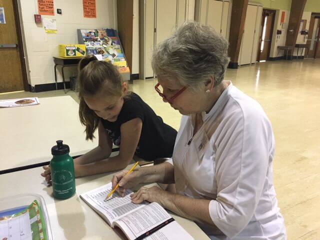 Dawn Hynes works one-on-one with a third grader to improve reading skills.