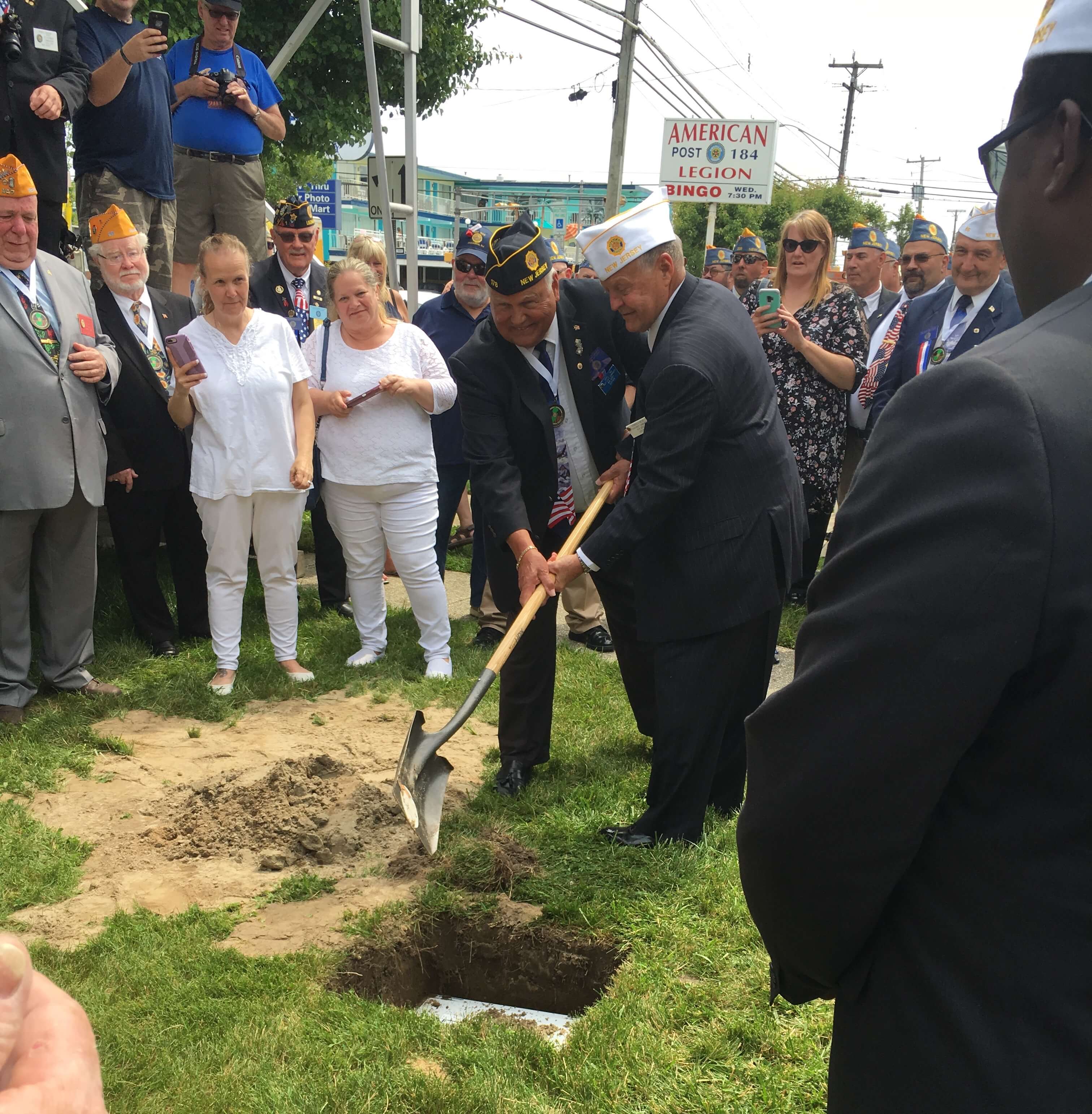 Incoming state commander Ray Miller and outgoing commander Darryl Reid shovel gravel onto a time capsule June 9 during the centennial of the New Jersey American Legion.