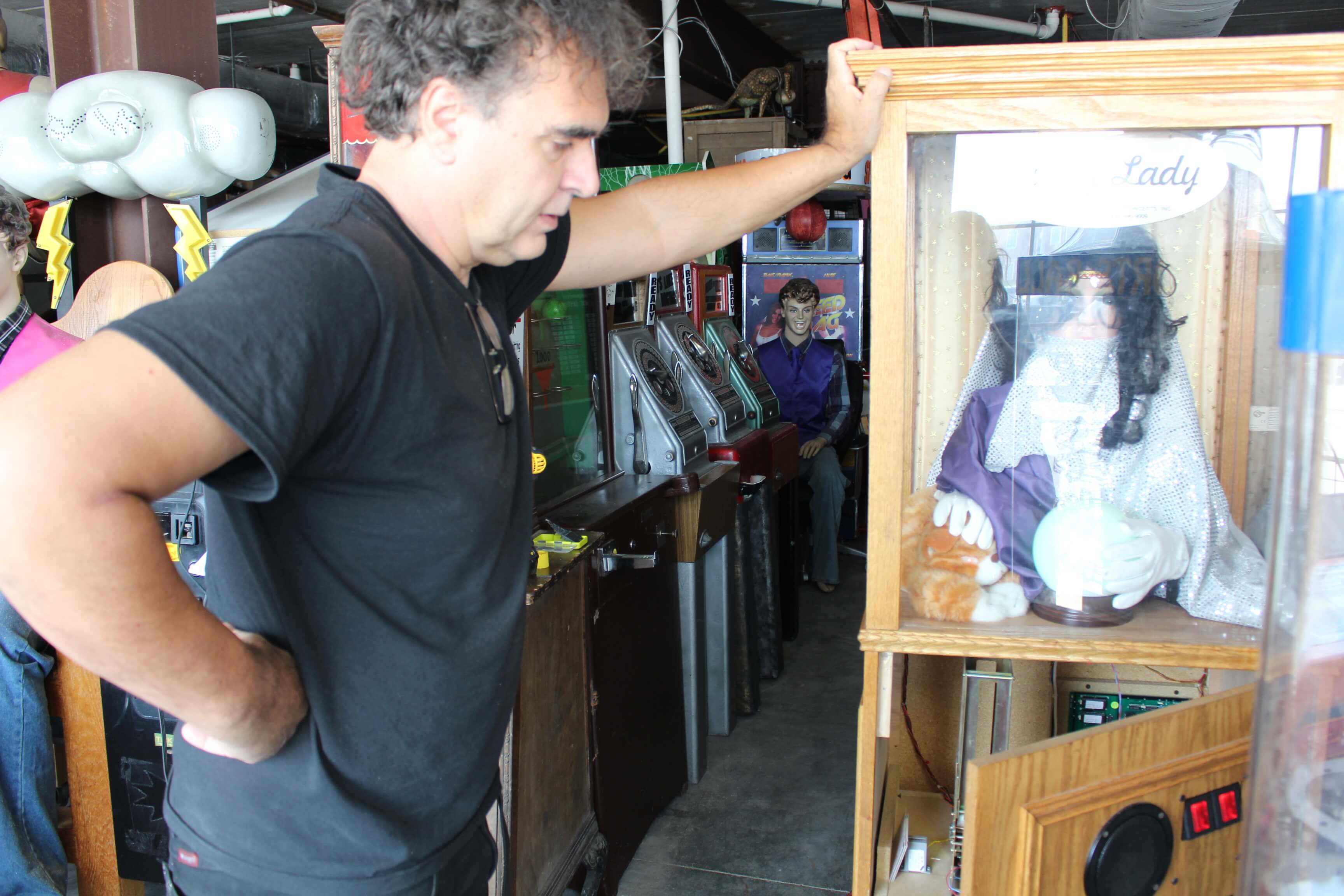 Randy Senna inspects a fortune telling game at the future location of the Retro Arcade on June 13. 