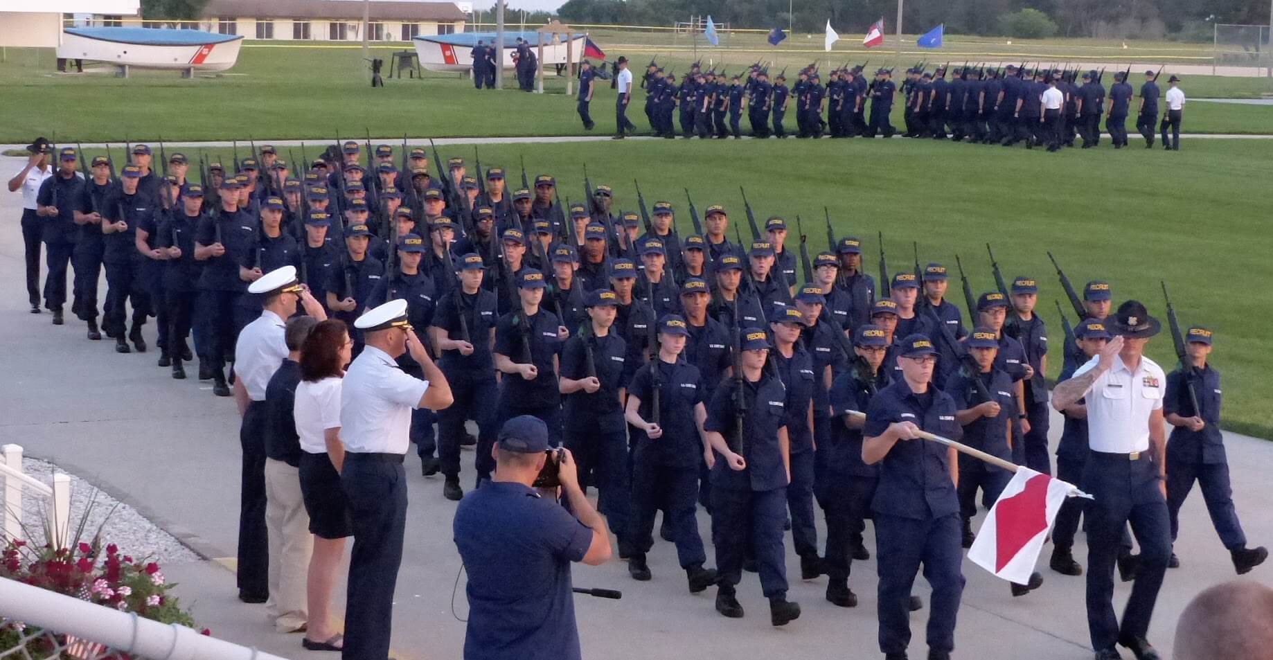 The official party headed by Capt. Owen Gibbons reviews recruit battalions at the conclusion of the July 1 Sunset Parade at Coast Guard Training Center Cape May.