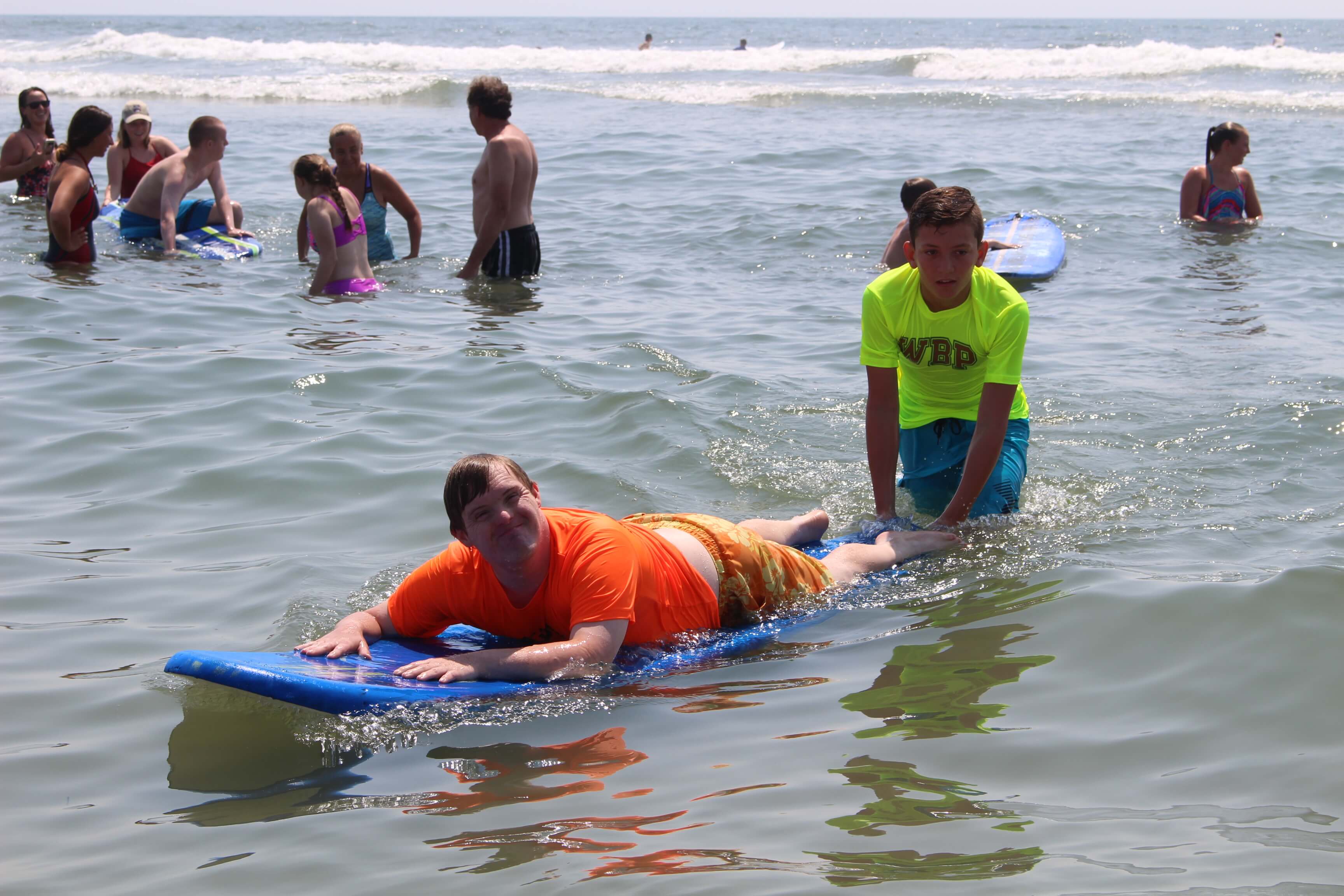 A lifeguard helps a bather ride a paddleboard at the 10th annual Beach Day hosted by Wildwood Beach Patrol and 21 DOWN July 16.