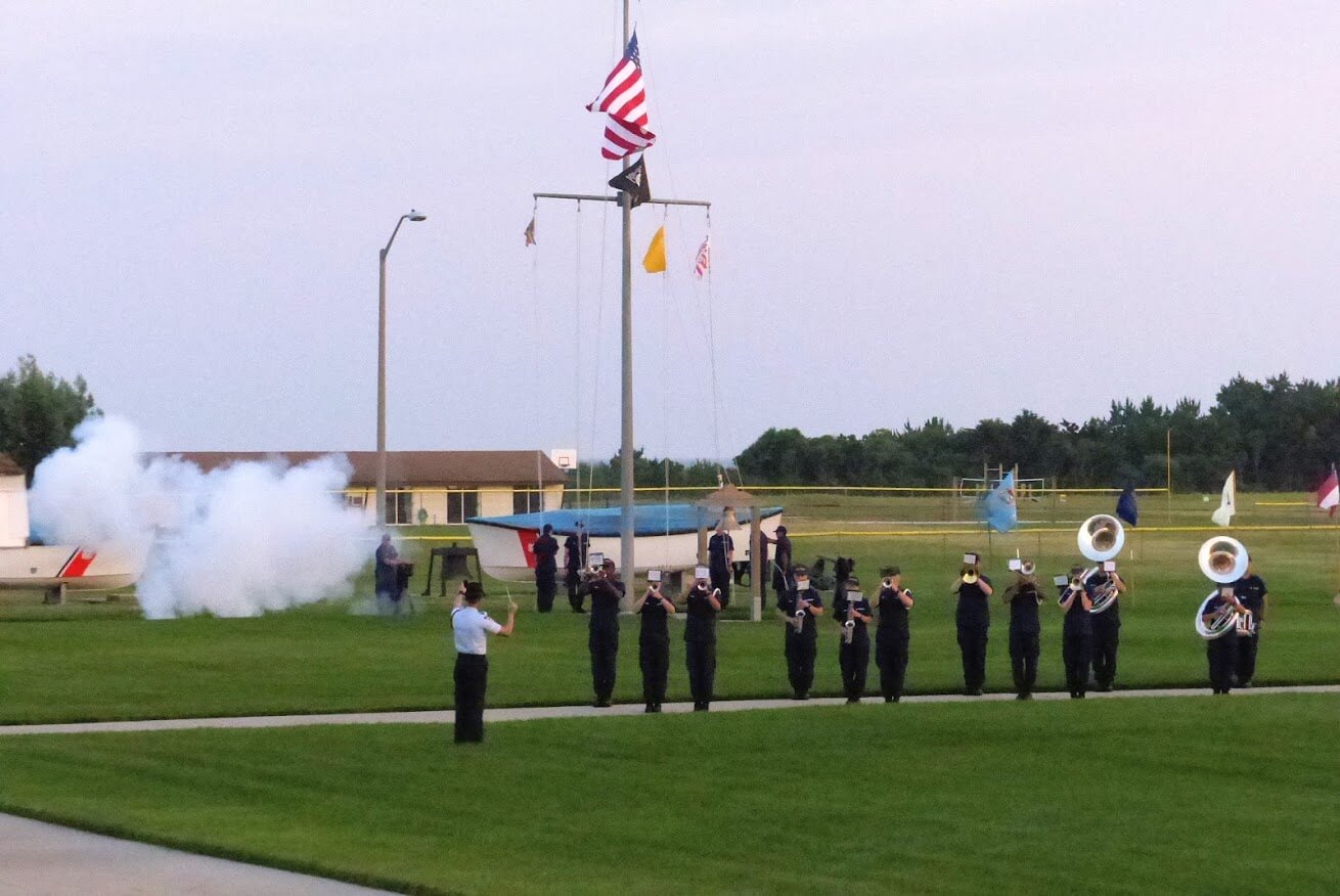 Cannon fired at Coast Guard's July 1 Sunset Parade begins striking of the colors as the Recruit Training Center Band plays the national anthem. A similar scene is scheduled to take place Sept. 2.