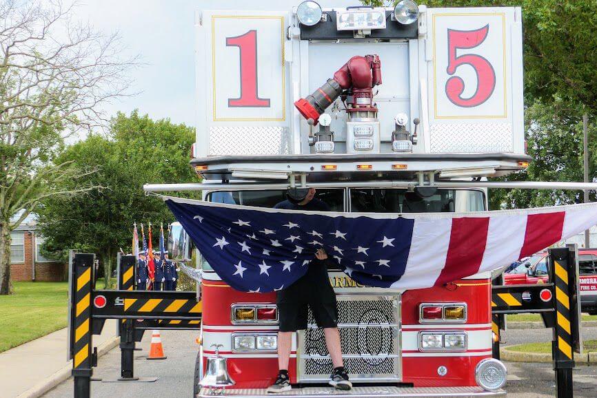 Marmora Volunteer Fire Department’s large American flag is prepared to be hoisted to commemorate the county’s 17th Annual Sept. 11 Memorial Ceremony as Coast Guard Ceremonial Detail recruits prepare to enter the County Administration Building. 