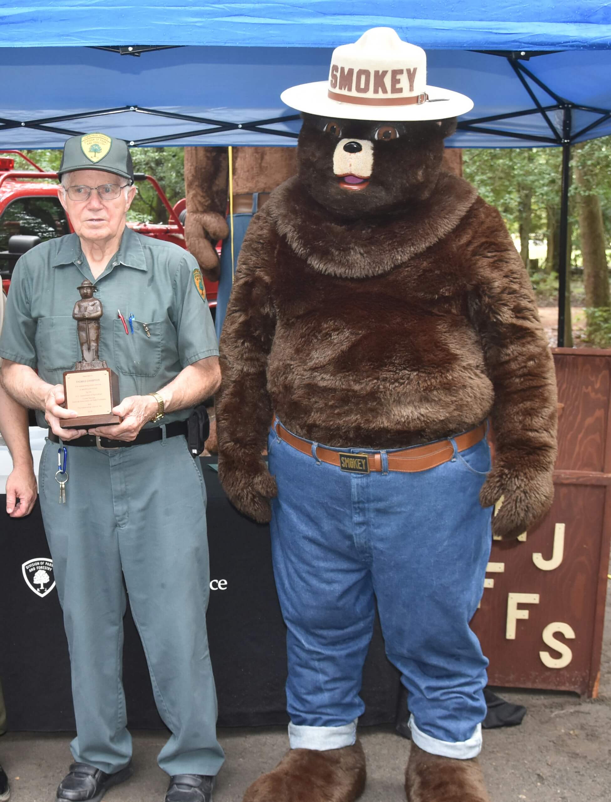 Tom Champion receives a bronze Smokey Bear award recognizing his efforts regarding fire prevention.