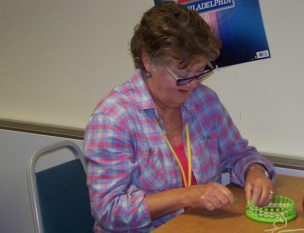 Retiree Donna Soennichsen helps knit at Specials Services.