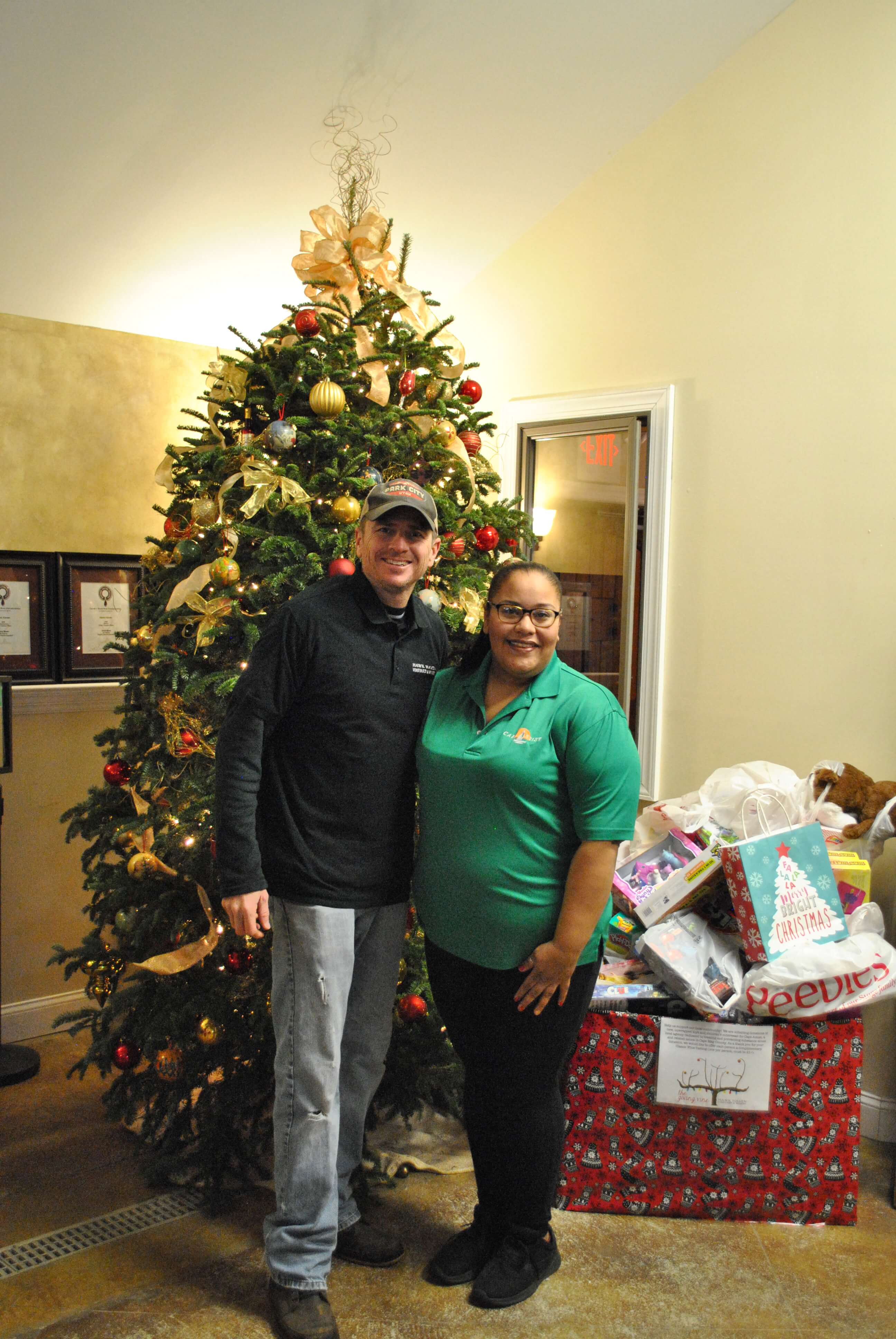Winemaker Todd and Chely of Cape Assist stand with two big boxes of children’s toys and outwear.