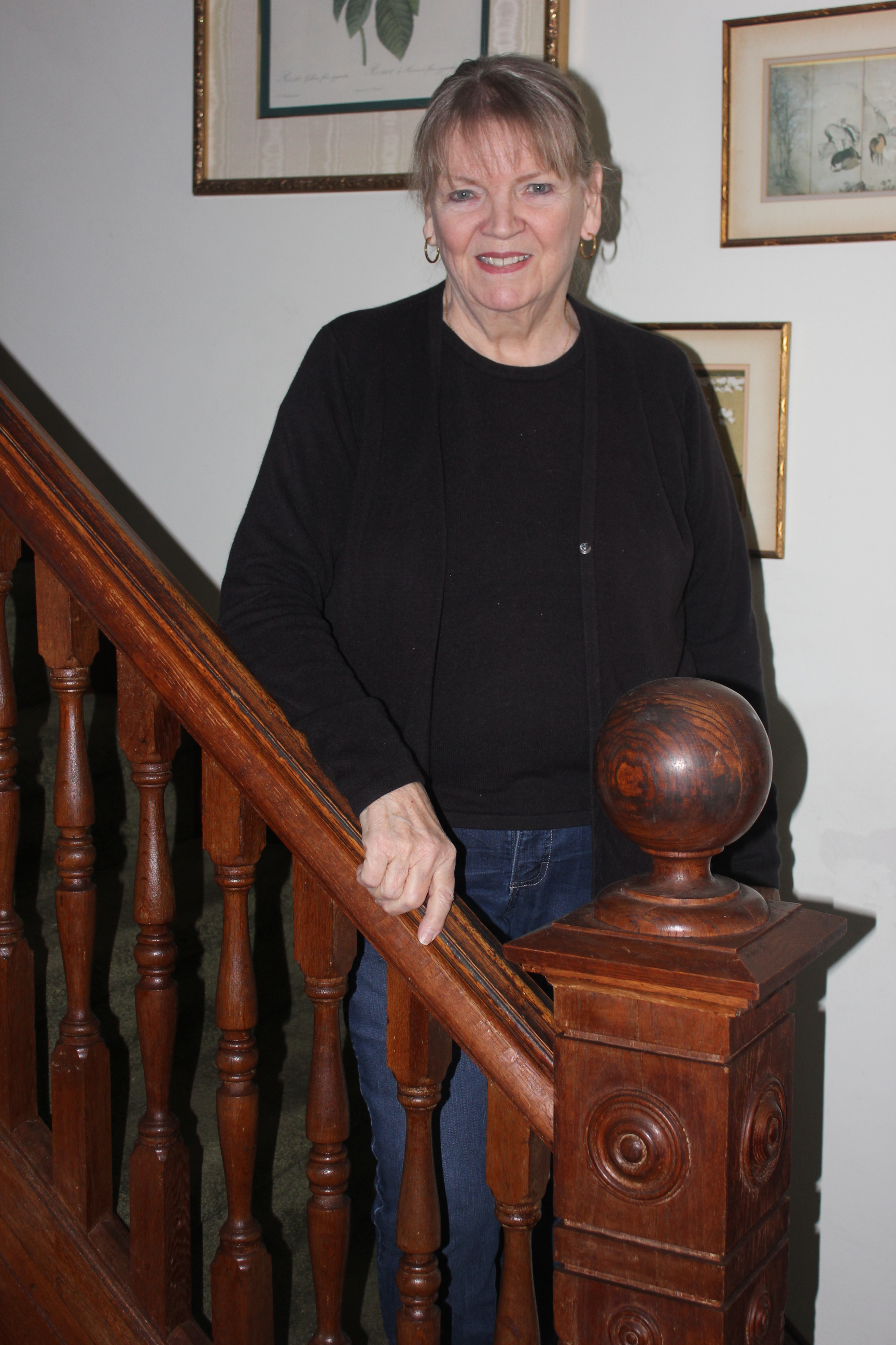 Evelyn Wagenhoffer descends the oak staircase that was painted white by a previous owner. The wood was restored and stained to bring it back to original condition.
