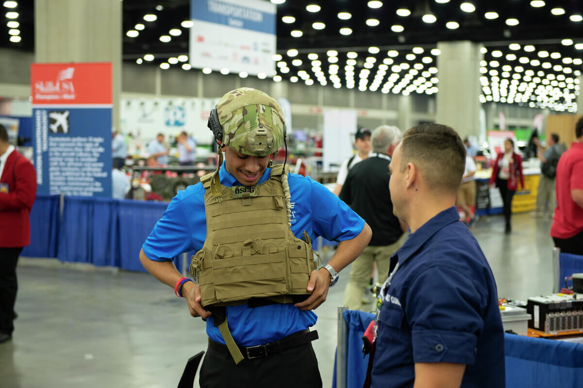 It's a fit. A potential recruit tries on a flak jacket as he learns about opportunities within the Coast Guard at the SkillsUSA event