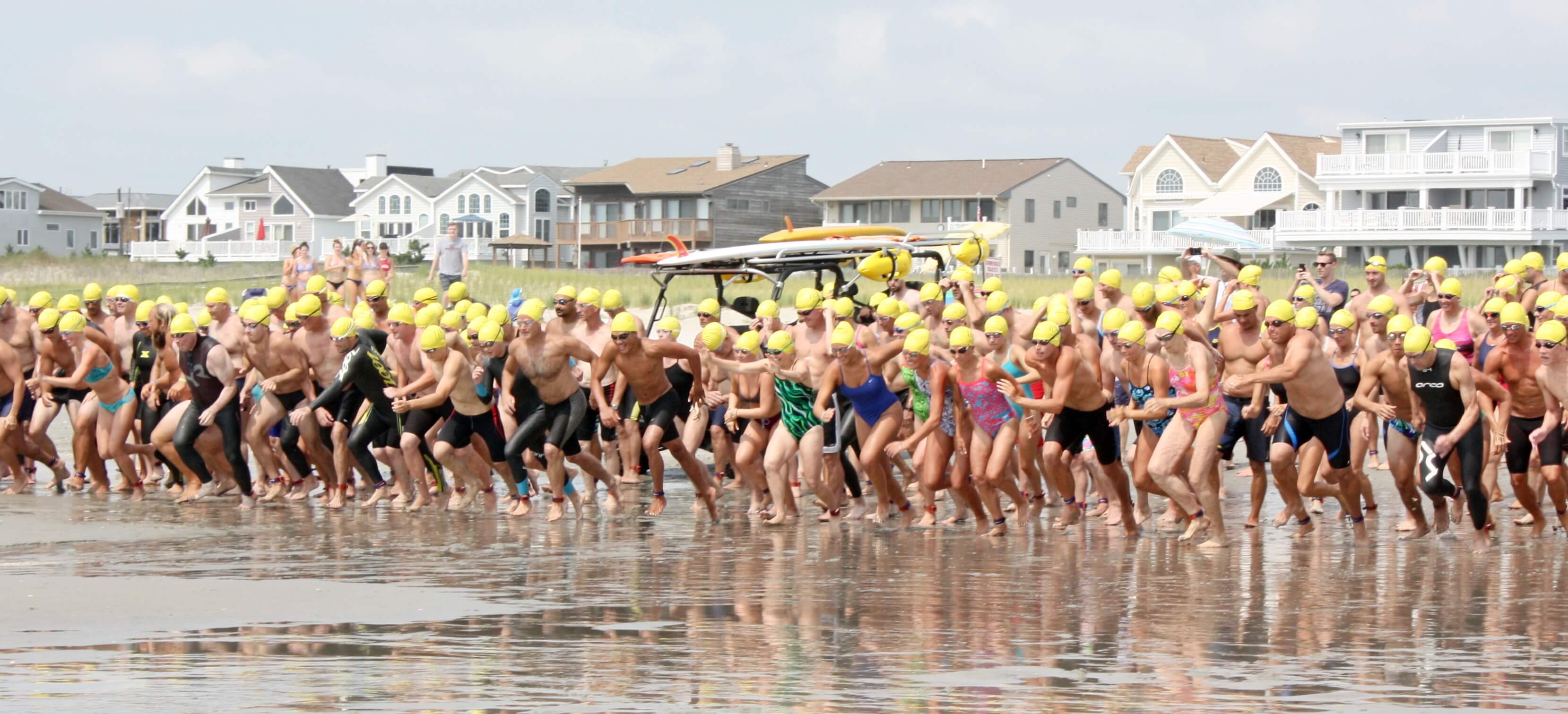 Swimmers are shown at the starting line and rushing into the ocean during a past 1-Mile Ocean Swim in Sea Isle City.