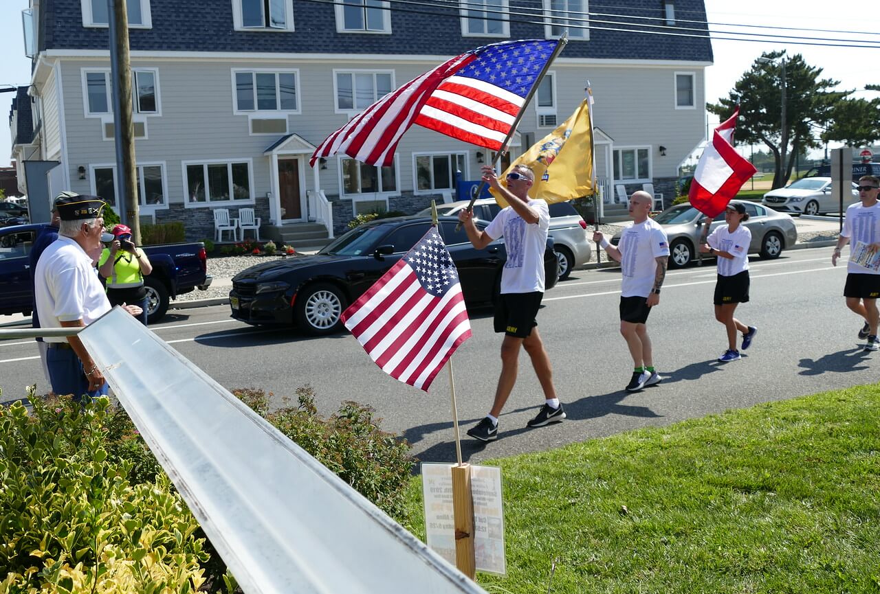 Runners in the New Jersey Run for the Fallen prepare to hand flags to American Legion Post 331 members