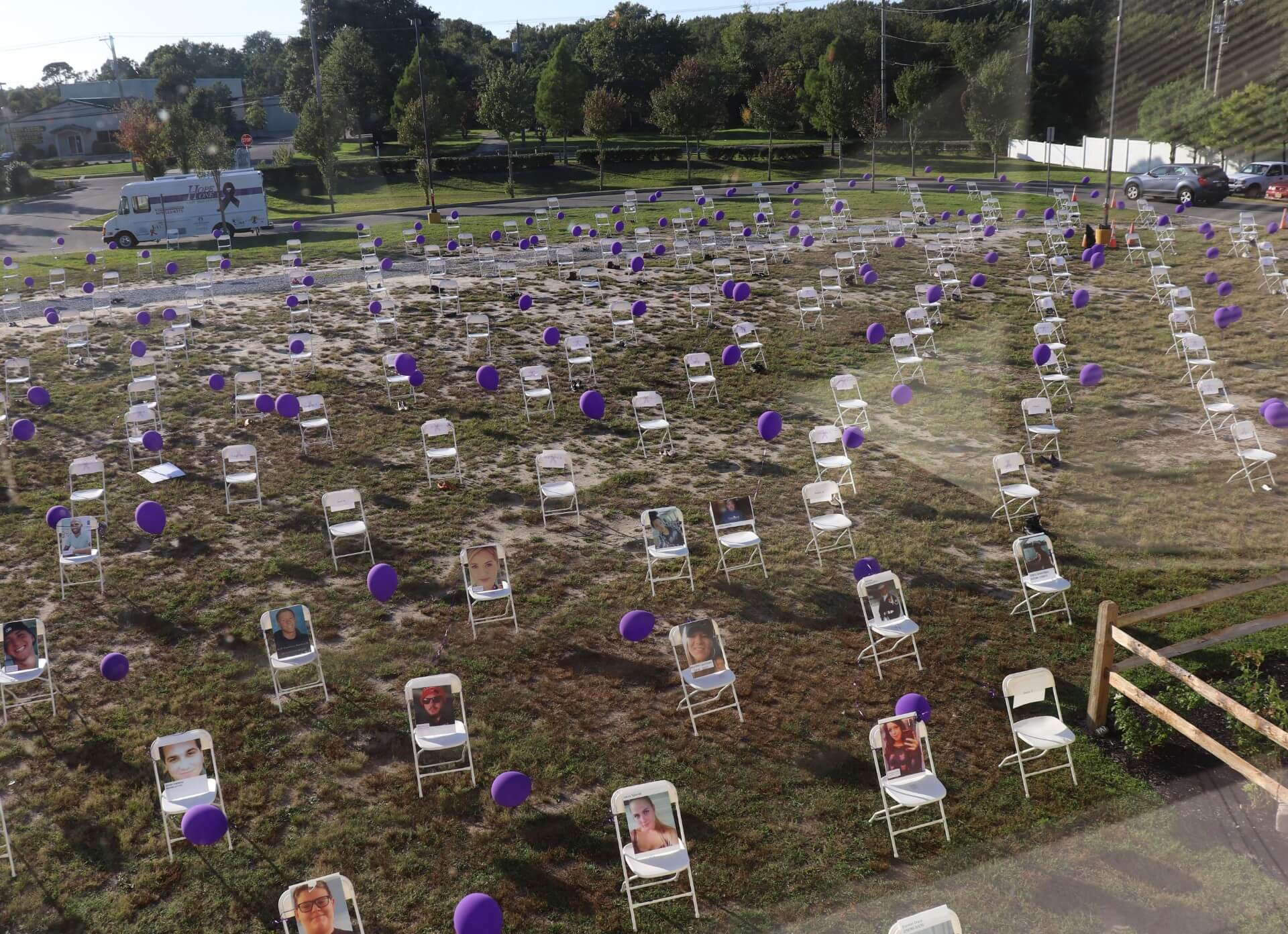 Two hundred sixty four empty chairs with balloons and pictures sit on the Lighthouse Church grounds