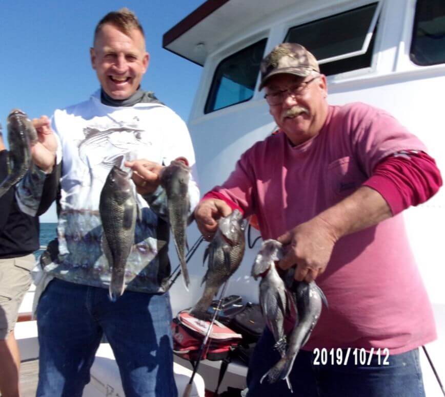 Happy anglers with their sea bass.