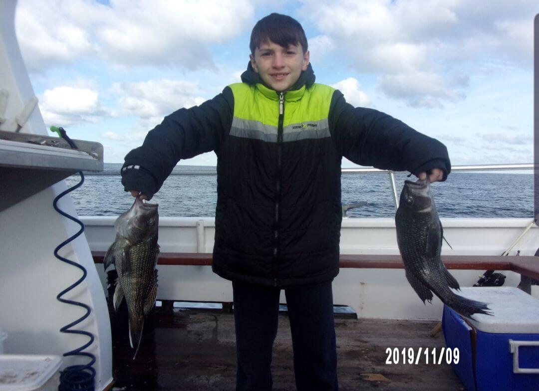 A young angler and his sea bass.