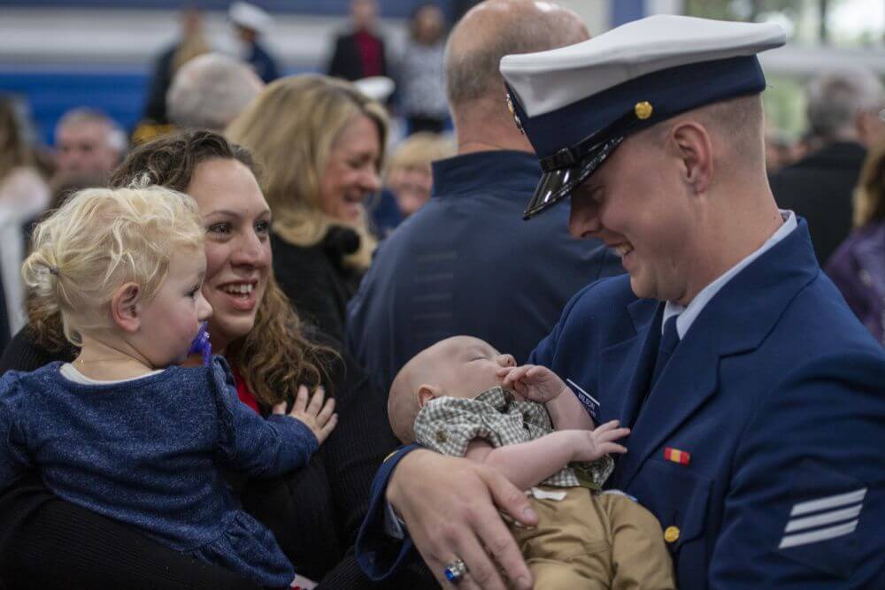 Coast Guard Seaman Ryan Wilson graduated from recruit training Nov. 22 and meets his newborn son after the ceremony.