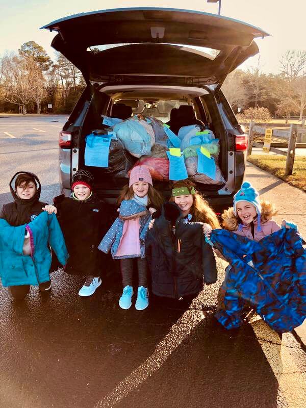 Children from Dennis Township help load donated coats that went to various local organizations to aid those in need. The event was sponsored by the Dennis Township Education Association.