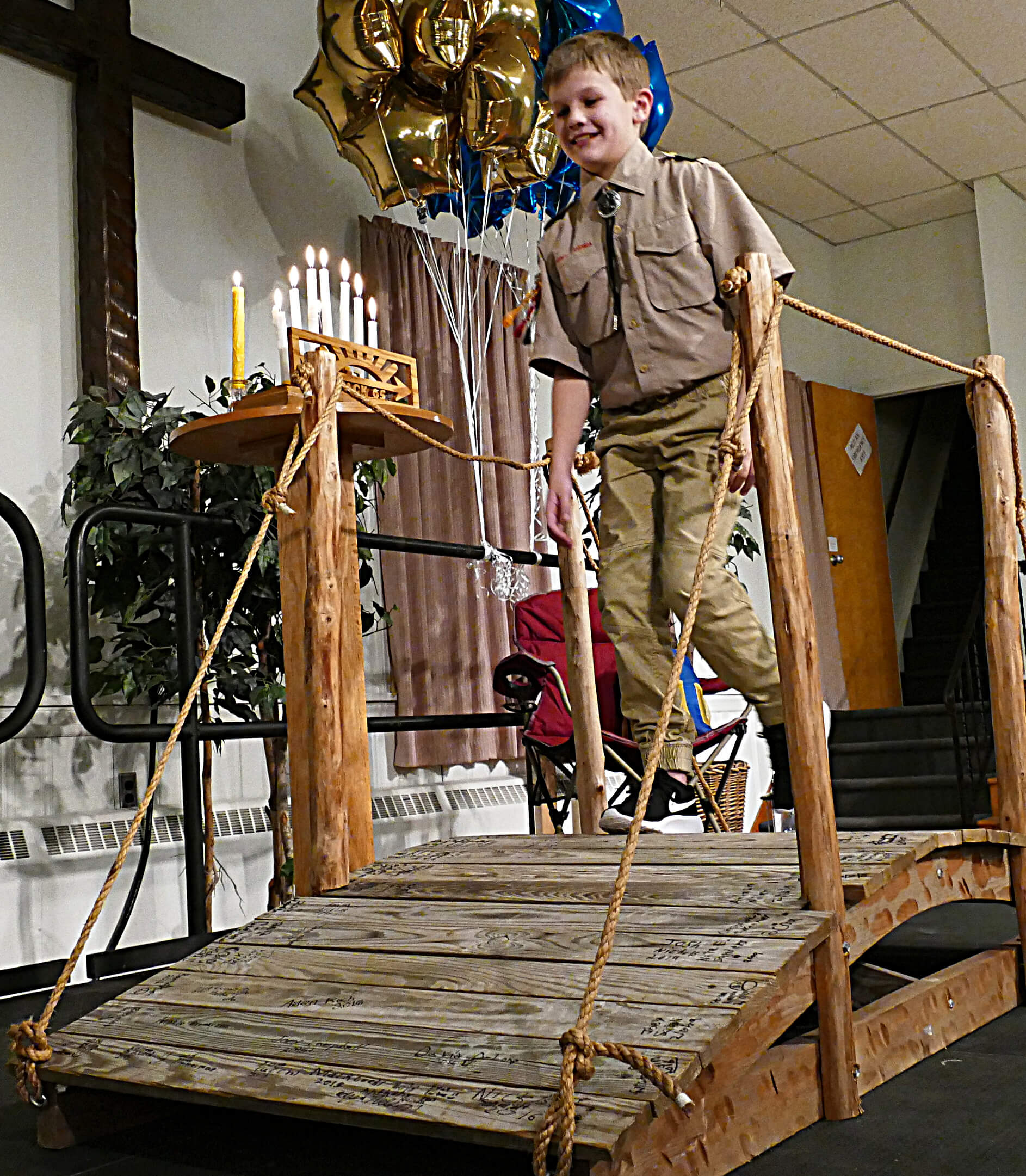 Arrow of Light Cub Scout Tyler King crosses ceremonial bridge to  Boy Scout Troop 65 Feb. 3 during Blue and Gold celebration at First United Methodist Church