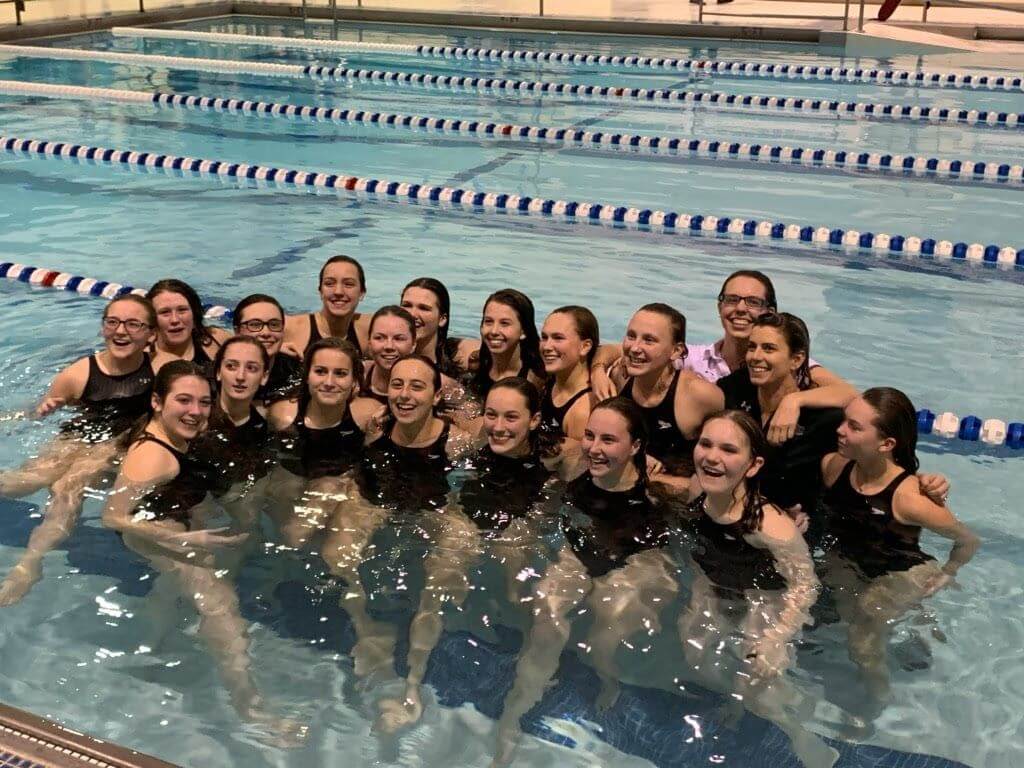 The Lady Hawks swim team poses for a photo in the pool. Head coach Dawn Dudley was impressed with how younger swimmers improved this season.