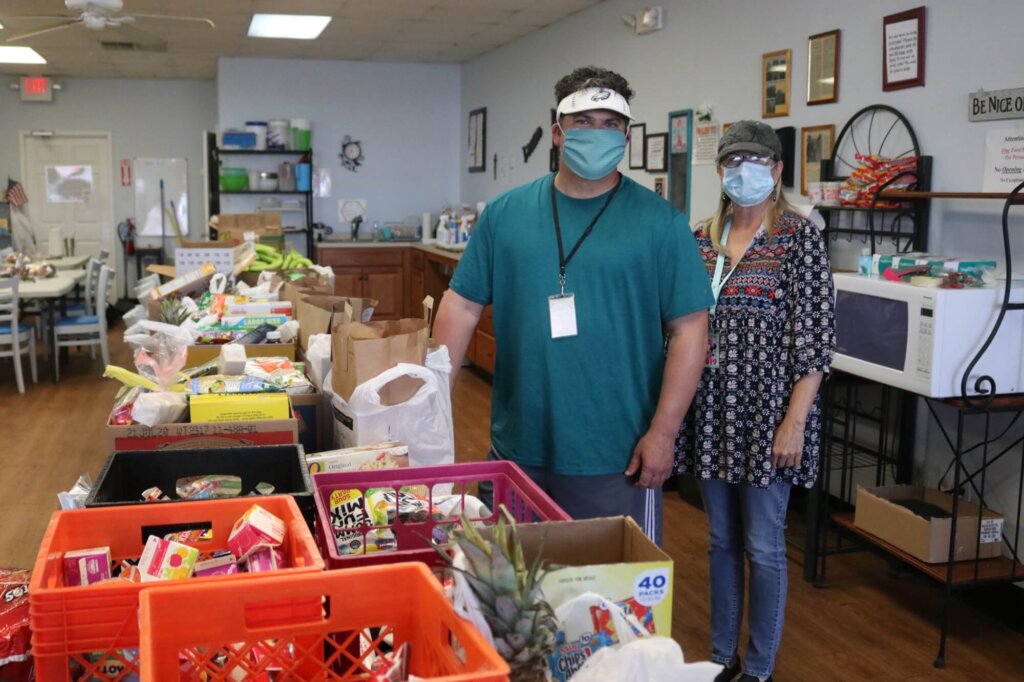 Volunteers Sean Smith and Becky Brown fill food bags at The Branches