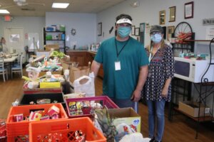 Volunteers Sean Smith and Becky Brown fill food bags at The Branches