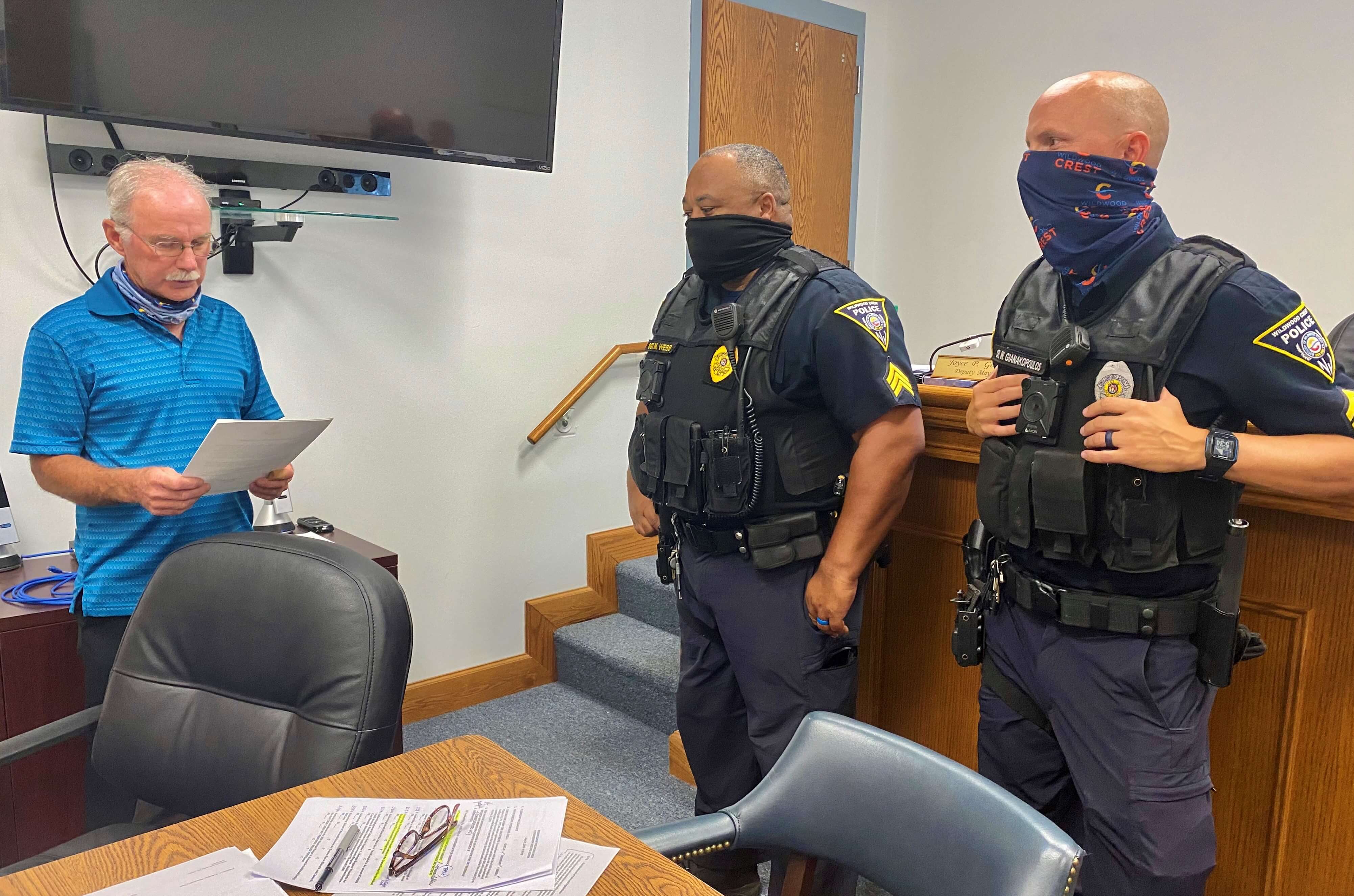 Wildwood Crest Commissioner of Public Safety David Thompson (left) reads a commendation honoring Sgt. Matthew Christopher Webb (center) and Cpl. William Gianakopoulos during the July 22 meeting of the borough's Board of Commissioners.