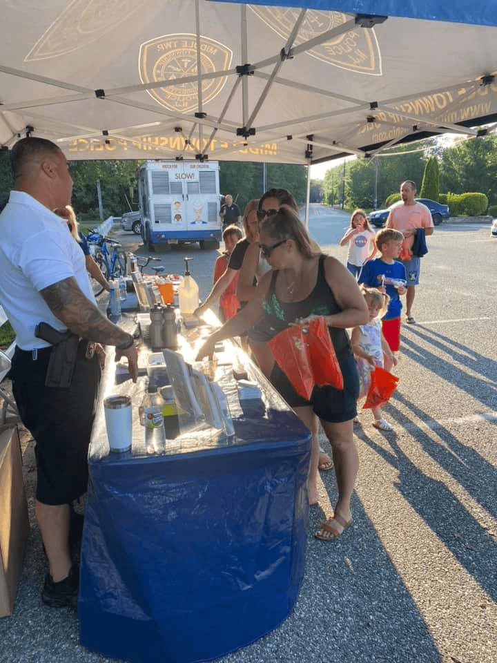 A Middle Township police officer speaks to residents at a Cones and Cops event
