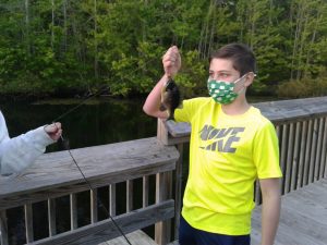 4-H Tightlines Fishing Club member Eddie examines a recent catch from the Ockie Wisting Recreational Complex May 10. 