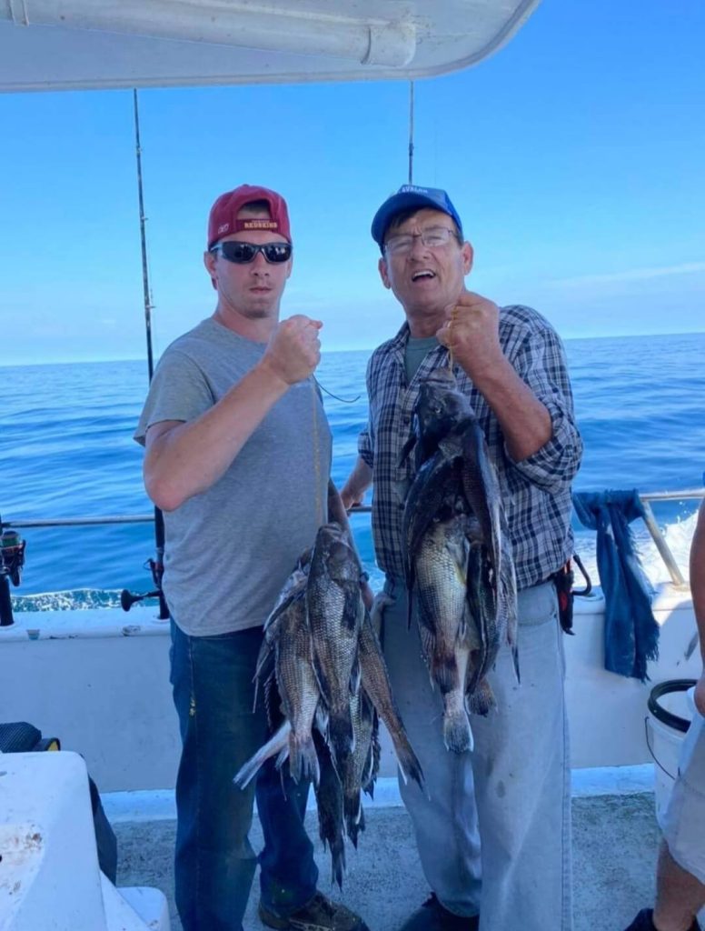 Two happy anglers with their sea bass stringers.