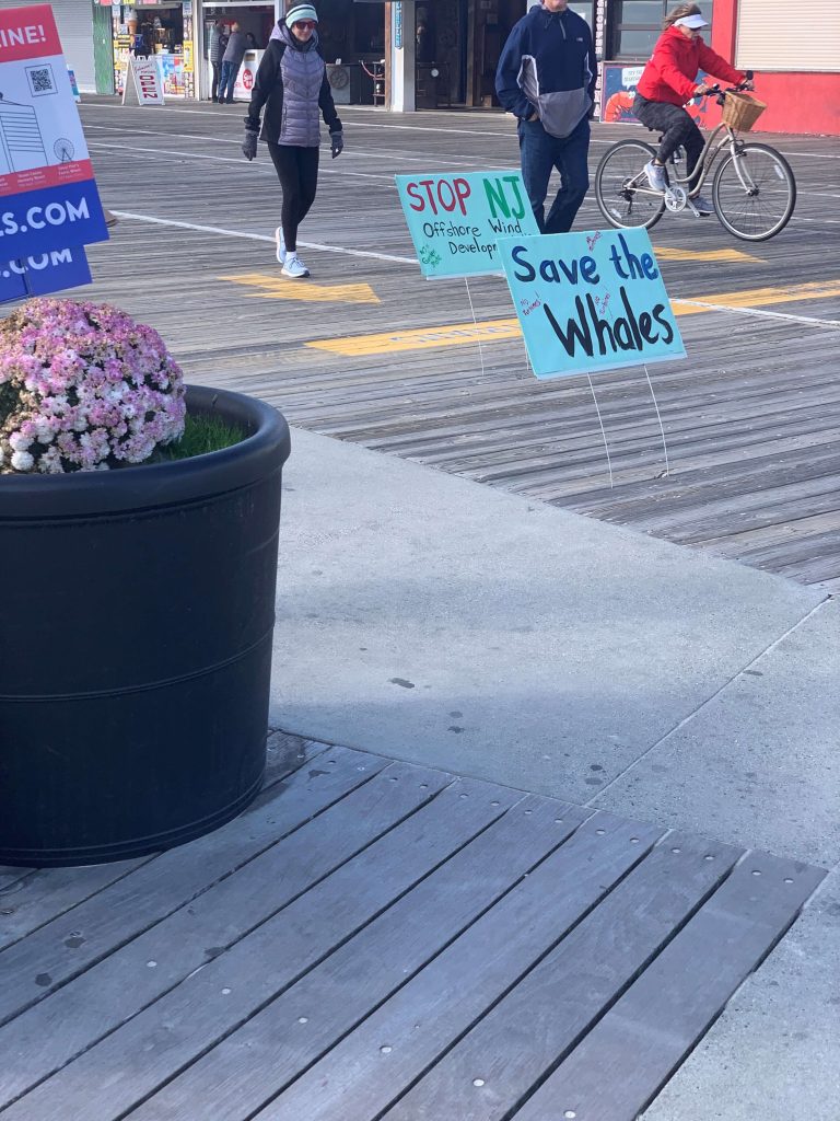 Protestors against the proposed offshore wind farms set up and held signs along the Ocean City boardwalk outside the event.