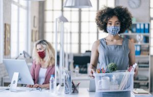 Businesswoman with protective face mask quits job due to limiting workplaces in office