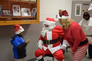 Jeyvon holds a candy cane and visits with Santa Claus at Hamer’s School of Karate’s annual Christmas party.   