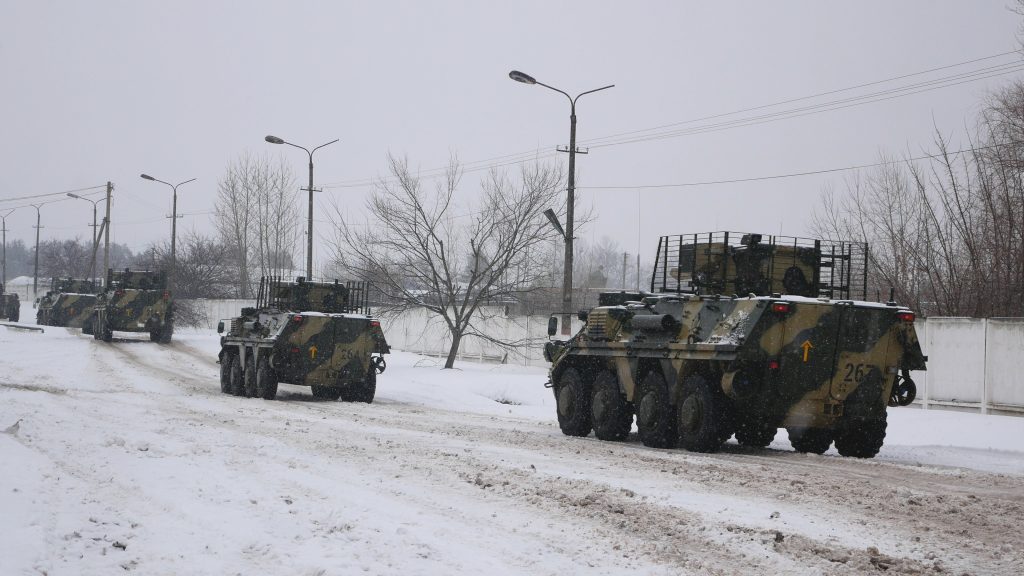 A column of armored personnel carriers rides on a winter road in Kharkiv